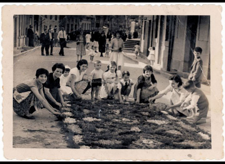 Mozas e nenos de San Benito facendo unha das tradicionais alfombras de Corpus. / Foto Magno [Ca. 1960] / PROCEDENCIA: Recollida O Porriño. Album familiar de Carmen Domínguez Estévez